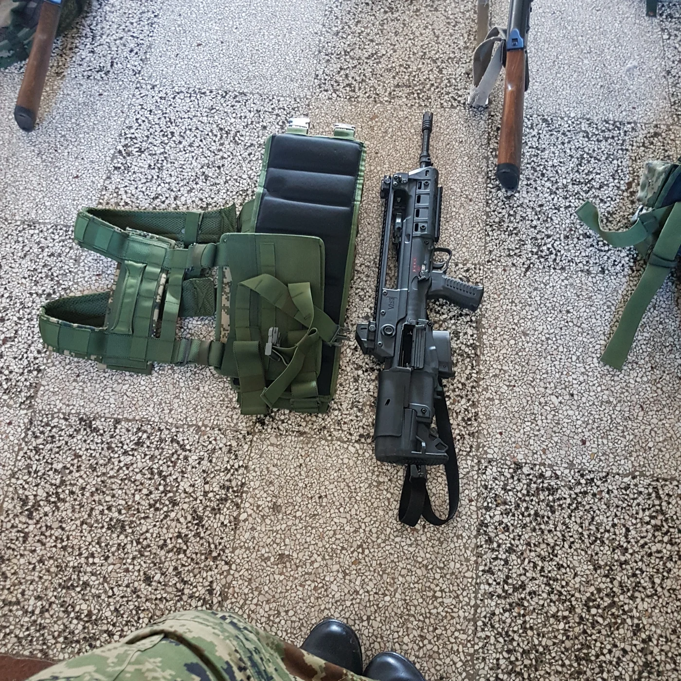 Chest rig and service rifle laid out before a field exercise